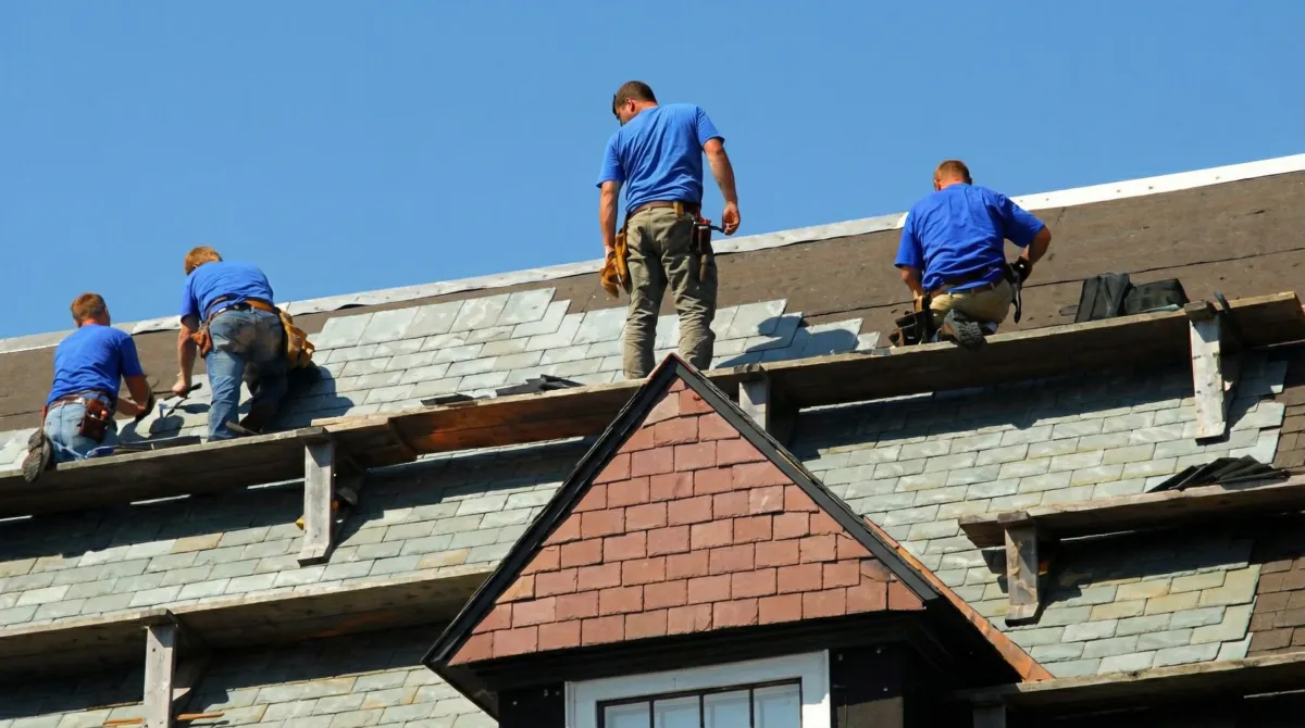 Roof replacement in progress with a team of professional contractors installing new shingles on a residential home in Miami, FL